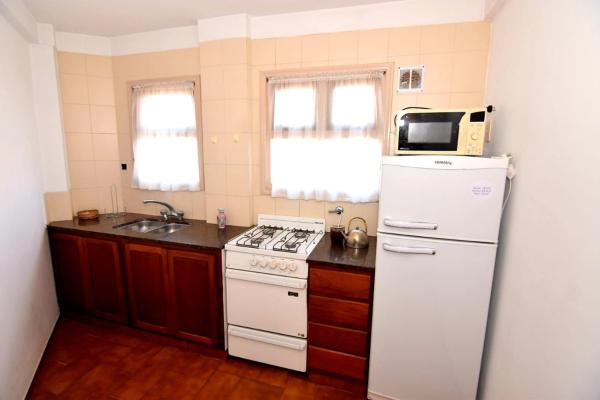 cocina con refrigerador blanca y microondas en COMPLEJO TRIUMPH en Mar del Plata