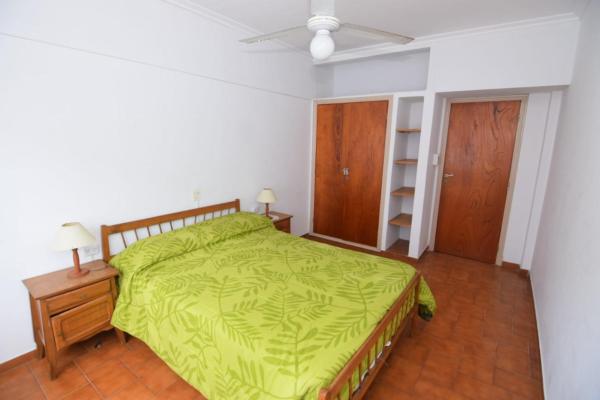 1 dormitorio con 1 cama verde y ventilador en COMPLEJO TRIUMPH en Mar del Plata