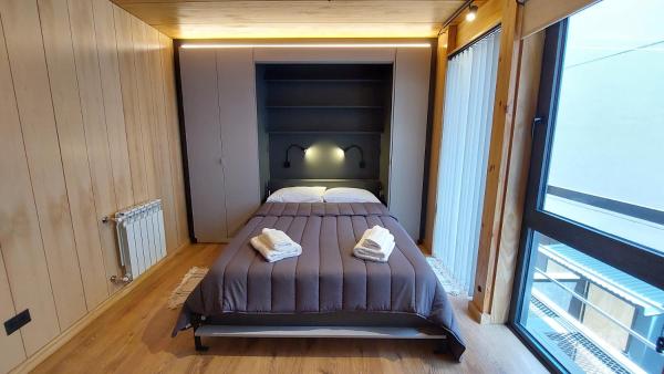 1 dormitorio con 1 cama en una habitación con ventana en Departamento de diseño, muy bien ubicado en el centro de SMA 13V5 en San Martín de los Andes