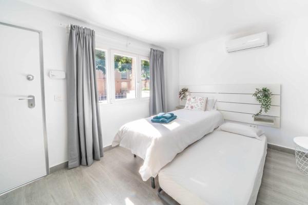 Habitación blanca con cama y ventana en Balneario Pedregalejo Loft A, en Málaga