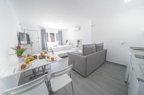 sala de estar blanca con mesa y sofá en Balneario Pedregalejo Loft A, en Málaga
