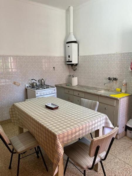 cocina con mesa con sillas y fregadero en Chalet en Mar del Plata en Mar del Plata