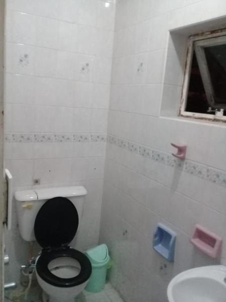 baño con aseo negro y lavamanos en Habitación para 4 con baño privado en Salta