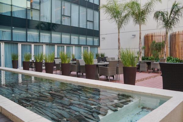 una piscina frente a un edificio con mesas y sillas en Hotel Treinta-Seis en Mar del Plata
