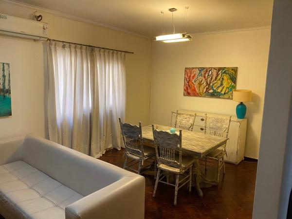 sala de estar con sofá, mesa y sillas en Departamento Av. España en Mendoza