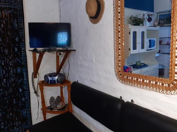 una sala de estar con televisión y espejo en el Edificio Los Caracoles de Villa Gesell