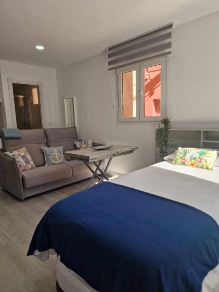 1 dormitorio con 1 cama grande y 1 sofá en Balneario Pedregalejo Loft B, en Málaga
