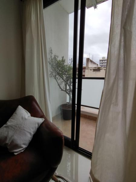 una silla con una almohada frente a una ventana en Departamento boutique en Salta en Salta