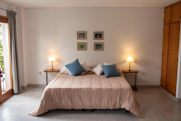 1 dormitorio con 1 cama grande y 2 lámparas en Lapacho Amarillo, departamento turístico Salta en Salta