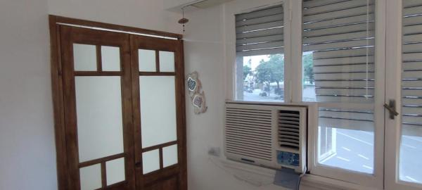 Habitación con puerta y ventana con persianas en APARTAMENTO OCHAVA Promos x paquetes Conversión Dolar Oficial en Buenos Aires