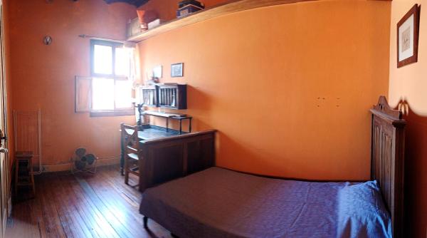 1 dormitorio con pared de color naranja, cama y ventana en Casa Colonial 3 piso Escalera en Buenos Aires