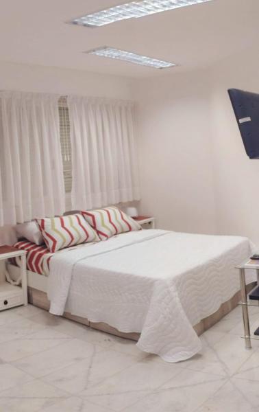 1 dormitorio con 1 cama con sábanas blancas y ventana en APARTAMENTO OCHAVA Promos x paquetes Conversión Dolar Oficial en Buenos Aires