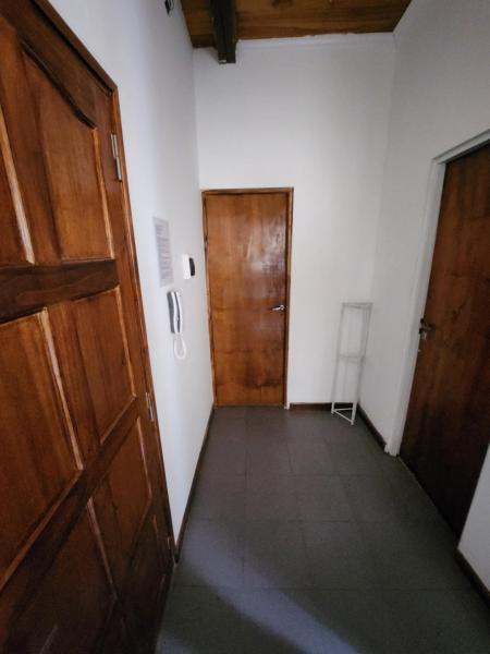 pasillo con puerta de madera y silla en Departamento ubicadisimo con estacionamiento incluido capital Mendoza 5 en Mendoza