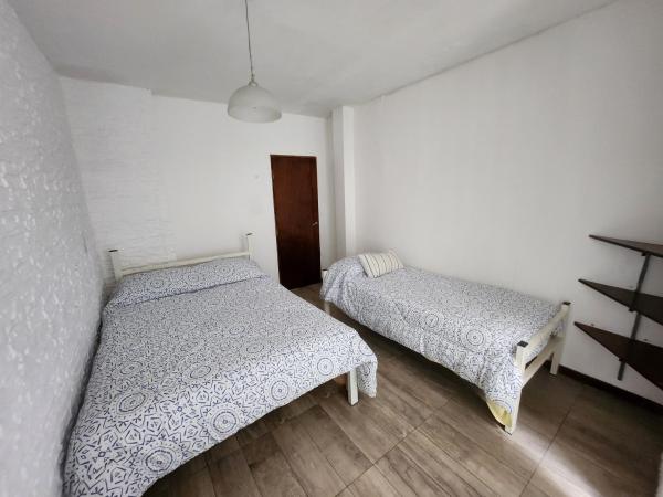 1 dormitorio con 2 camas y puerta en Departamento ubicadisimo calle Chile con estacionamiento incluido capital Mendoza3 centro en Mendoza