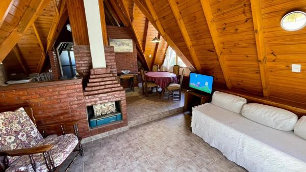 sala de estar con sofá y chimenea en La Cabaña de Puerto Madryn en Puerto Madryn