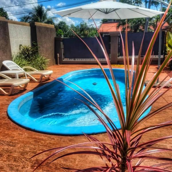 una piscina en un patio con sombrilla en Complejo Solar Del Iguazu 1 en Puerto Iguazú