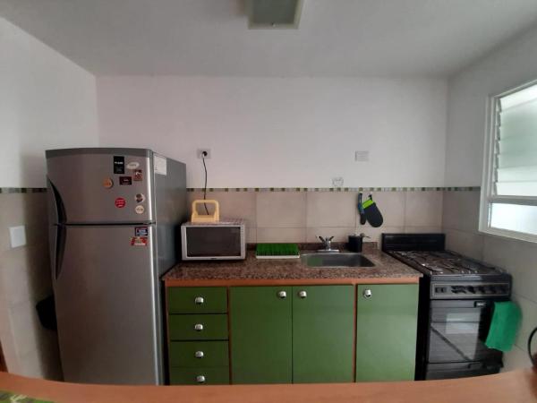 una pequeña cocina con refrigerador y fregadero en Cálido, luminoso & excelente ubicación BA en Buenos Aires