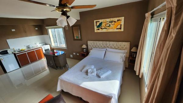 1 dormitorio con 1 cama y ventilador de techo en Departamentos Mirando AL MAR en Villa Gesell