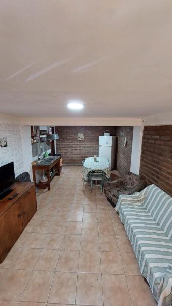 sala de estar con sofá y pared de ladrillo en Elst House en Mendoza