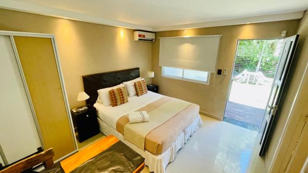 1 dormitorio con cama y ventana grande en Ayres Village Apart en Pinamar