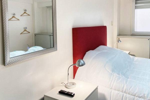 1 dormitorio con cama, espejo y lámpara en CORD0304 Hermoso y super cómodo Depto entero en el Centro en Buenos Aires