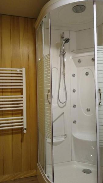 baño con ducha y puerta de cristal en Vivero 5, departamento 5 en San Martín de los Andes