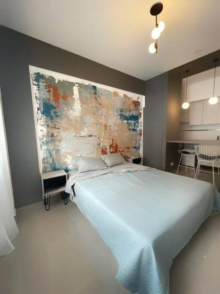 Un dormitorio con una cama azul con una pintura en la pared en Apartamentos in the museum house en Buenos Aires