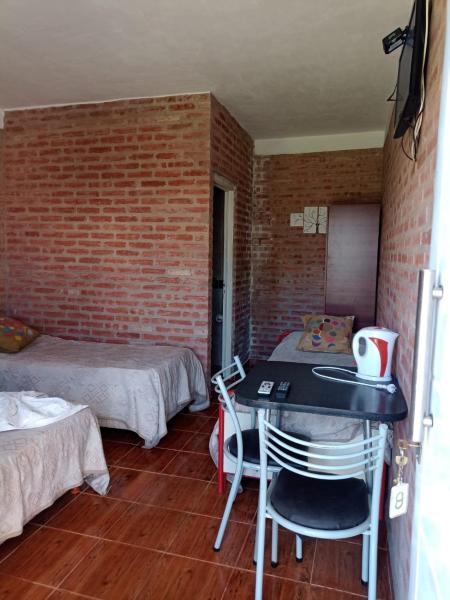 Habitación con 2 camas, mesa y sillas en Complejo Navi, en Mina Clavero