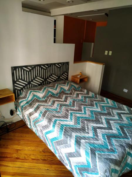 1 dormitorio con 1 cama con un edredón colorido en Departamento Unico en Recoleta !! Ubicacion Excelente. en Buenos Aires