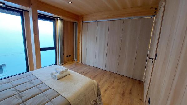 1 dormitorio con cama grande y ventana grande en Hermoso y cálido departamento en el centro de SMA, 21V5 en San Martín de los Andes