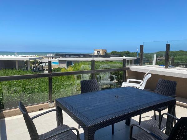 una mesa azul y sillas en el balcón en Linda Bay Beach & Resort Studio 304 en Mar de las Pampas