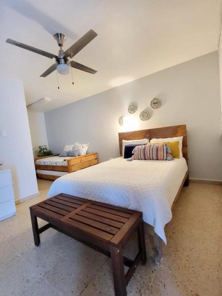1 dormitorio con 1 cama y ventilador de techo en Bee Inn Puerto Rico Charming Urban Apartment in San Juan, en San Juan