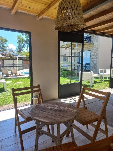 una mesa y 2 sillas en un porche con mesa y ventanas en Piedra Mora Loft en Gualeguaychú