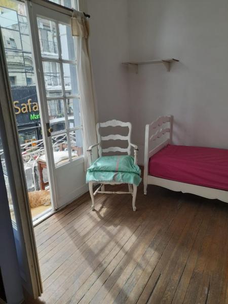 Habitación con cama, silla y ventana en Corazón de Recoleta en Buenos Aires