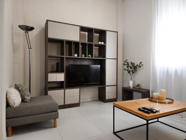 sala de estar con TV, sofá y mesa en G&G Apartments - Recoleta Boutique Experience en Buenos Aires