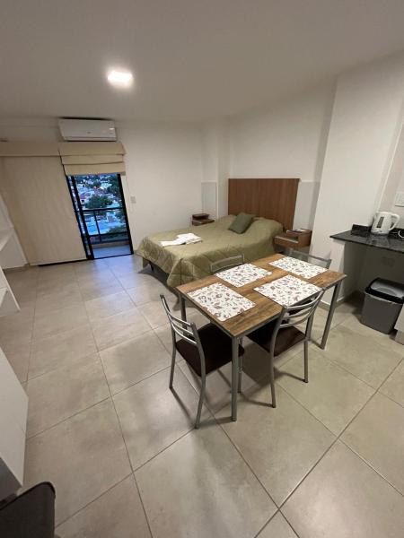 Habitación con cama, mesa y sillas. en ARENALES 742/403-404 en Salta