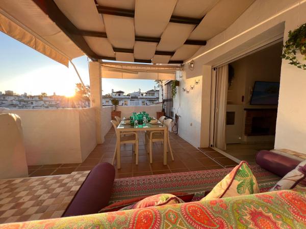 Habitación con balcón con mesa y sofá. en South of the Sun, en Marbella