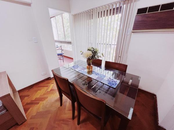 una mesa de comedor con un jarrón de flores. en Departamento Peatonal Sarmiento en Mendoza