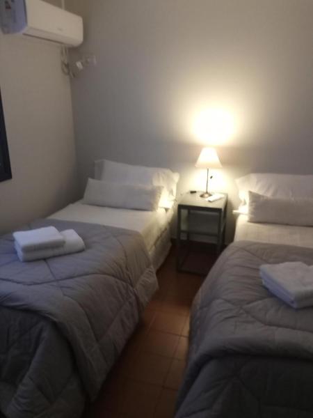 2 camas en una habitación con una lámpara en una mesa en La casita en Puerto Iguazú