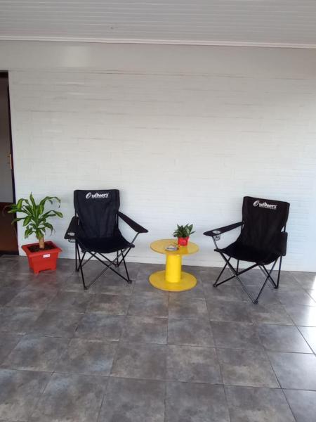 Dos sillas negras y una mesa amarilla en una habitación en La casita en Puerto Iguazú