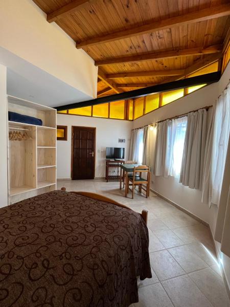 1 dormitorio con 1 cama grande y 1 mesa en Departamentos Amantea en Mar de las Pampas