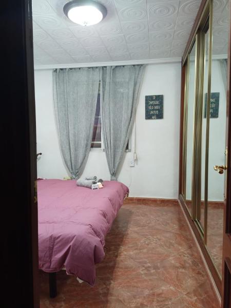 1 dormitorio con cama morada y ventana a Tourist room, en Valencia