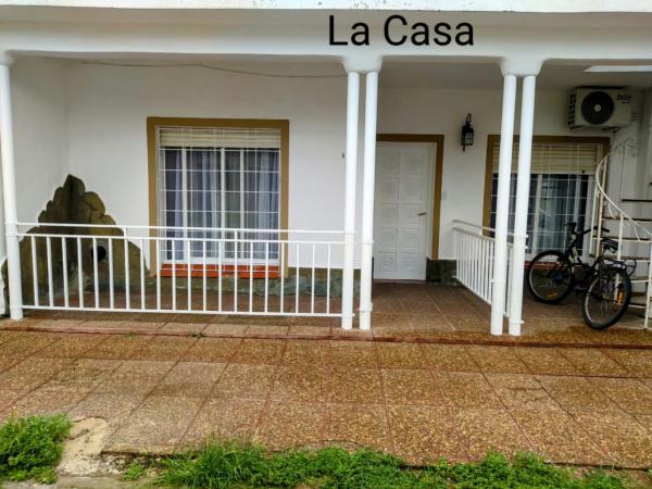 una casa blanca con una bicicleta estacionada en el porche en La casa en Gualeguaychú