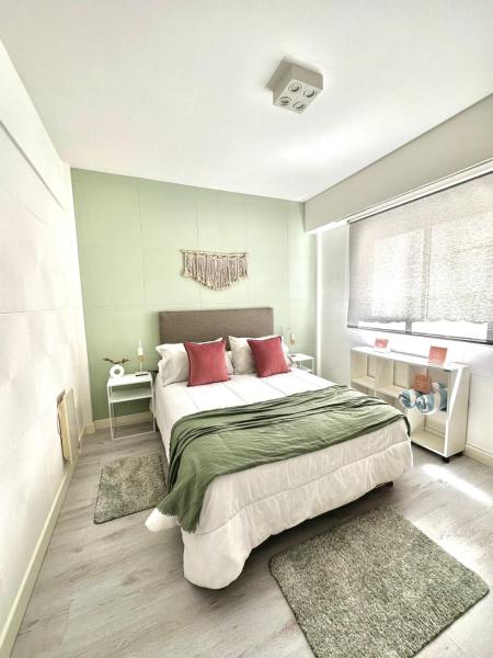 1 dormitorio con 1 cama grande con almohadas rojas en Departamento BOUTIQUE #HONOLULU- Nomade Suites -Mar del Plata en Mar del Plata