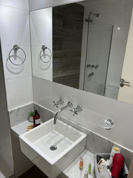 y baño con lavabo blanco y espejo. en Glamoroso departamento de 1 ambiente en belgrano en Buenos Aires