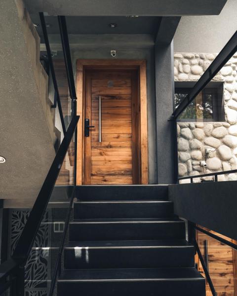 Una escalera con una puerta de madera en una casa en Rotui Exclusive Apartment en San Martín de los Andes