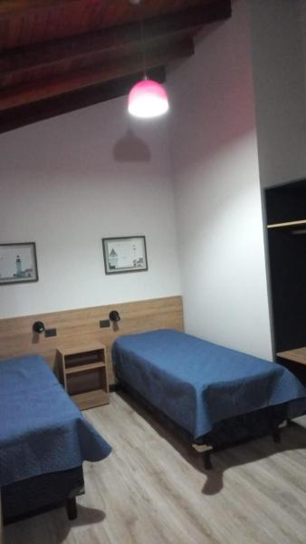 1 dormitorio con 2 camas azules y luz en Duplex Laurel en Puerto Iguazú