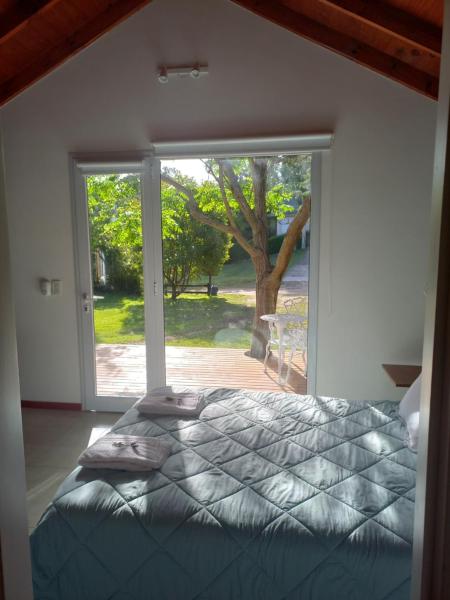 1 dormitorio con cama y ventana grande en Namarie 1 en Pinamar
