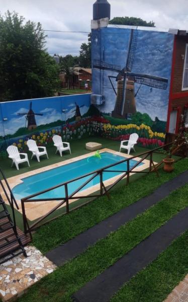 mural en el lateral de un edificio con piscina y molino de viento en Duplex Victoria, Puerto Iguazú en Puerto Iguazú