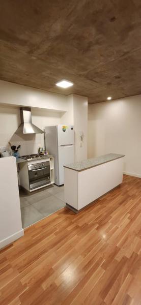 cocina con electrodomésticos blancos y suelo de madera en Dpto de 1 dormitorio y 1.5 baños con amenities en Belgrano R Villa Urquiza en Buenos Aires